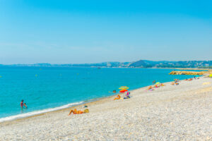 Kiesstrand von Cagnes-sur-Mer mit türkisblauem Meer und Blick Richtung Villeneuve-Loubet