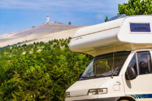 Wohnmobil am Waldrand mit Blick auf den Mont Ventoux und den Gipfel‑Sendeturm im Hintergrund