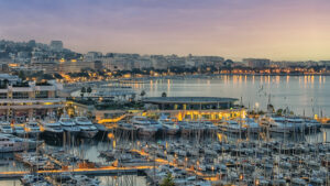 Hafen und Bucht von Cannes in der Dämmerung mit beleuchteten Booten und Uferpromenade