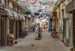 Einkaufspassage in Carpentras mit bunt bemalten Schirmen über den Geschäften