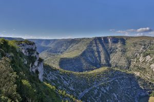 Weite Aussicht über die Kalkschlucht des Cirque de Navacelles mit Serpentinenstraße und Hochplateau