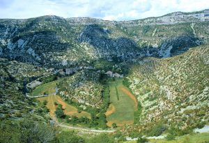 Panoramablick auf den Talkessel des Cirque de Navacelles mit altem Flussbogen der Vis und Dorf Navacelles