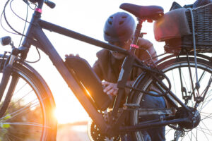 Mann mit Fahrradhelm setzt einen Akku in die Halterung am E-Bike-Rahmen ein