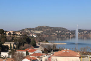 Étang de l’Olivier in Istres mit Wasserstrahl und Blick auf die umliegenden Hügel