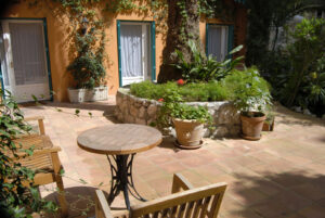 Holztisch und Stühle auf einem Patio in Nizza.