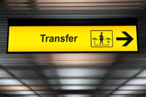 Gelbes Transferschild mit Pfeil nach rechts in einem Flughafenterminal