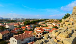 Aussicht von den alten Mauern in Fos-sur-Mer über Wohnviertel, rote Dächer und Industrieanlagen am Golf von Fos