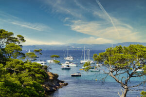 Boote vor der Insel Porquerolles mit Pinienküste und Blick auf das Festland
