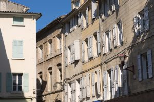 Häuserfassaden mit hellen Fensterläden in der Altstadt von Manosque