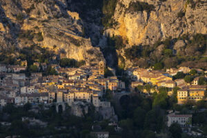 Moustiers-Sainte-Marie vor steilen Kalkfelsen im warmen Abendlicht