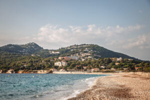 Plage de l'Almanarre in Hyères mit Meer, Uferbebauung und bewaldeten Hängen