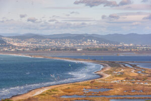 Blick über die Plage de l’Almanarre bei Hyères mit Lagunen, Wellen und Kitesurfern