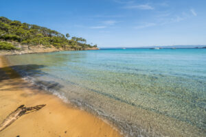 Plage Notre-Dame auf Porquerolles mit klarem Wasser, hellem Sand und Segelbooten vor der Küste