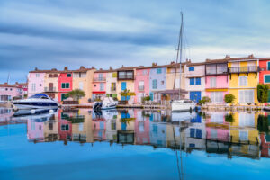 Pastellfarbene Häuser und Boote an einem ruhigen Kanal in Port Grimaud in Frankreich