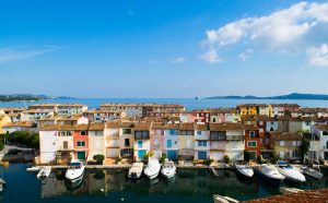 Bunte Häuser von Port Grimaud mit Booten am Kanal und Blick auf den Golf von Saint-Tropez