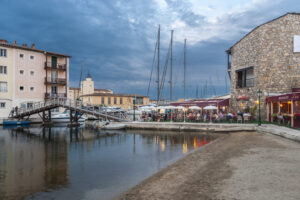 Restaurants am Wasser in Port Grimaud mit Brücke, Booten und Abendstimmung
