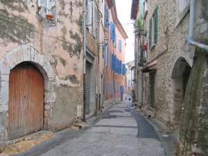 Schmale Altstadtgasse mit pastellfarbenen Häusern in Saint-Maximin-la-Sainte-Baume