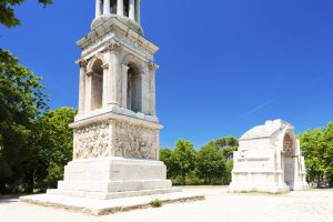 Römisches Mausoleum der Les Antiques bei Saint-Rémy-de-Provence vor blauem Himmel