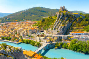 Panoramablick auf Sisteron mit Zitadelle, Altstadt, Steinbrücke und türkisblauer Durance