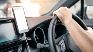 Smartphone mit Navigationskarte in einer Halterung im Auto